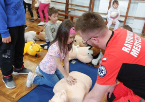 ratownik medyczny oraz uczennica ćwiczą masaż serca na fantomie
